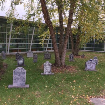 Fake headstones in the grass in front of the Calder Art Center building
